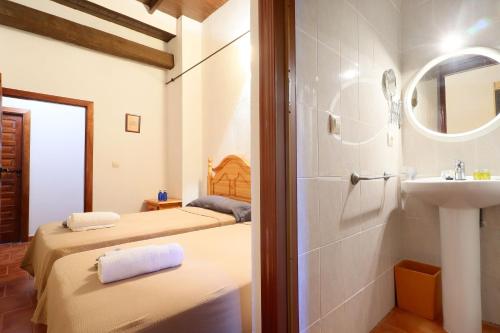 AdamuzCasa Rural Finca Los Conventos en Adamuz CORDOBA的浴室设有两张床、一个水槽和镜子
