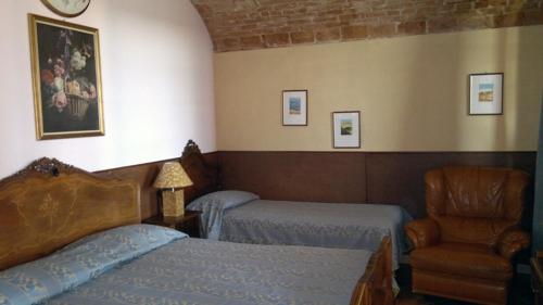 阿斯蒂卡萨塔瓦索酒店的一间卧室配有两张床和椅子