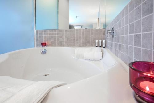 都柏林布斯特尔斯敦格里森斯联排别墅酒店的浴室设有白色浴缸及镜子