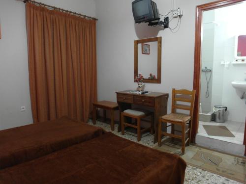 卡拉马塔亚历山大酒店的一间卧室配有一张床、一张书桌和一面镜子