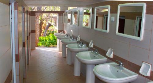 基萨莫斯诺皮基亚野营酒店的浴室设有一排盥洗盆和镜子