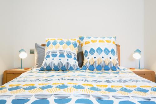 波思利文Finest Retreats - Luxury Holiday Let in Porthleven, Sleeping 2的一张带蓝色和白色床单的床和两个枕头