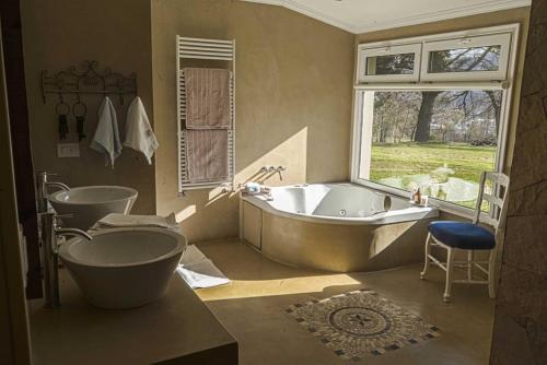 埃博森La Aguada的一间带两个盥洗盆、浴缸和窗户的浴室