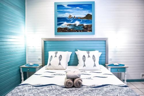 巴斯特尔Résidence Paradis Tropical的一间卧室配有一张蓝色床头板的床
