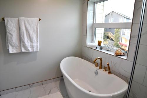 耶洛奈夫Aurora Guest house的带窗户的浴室内的白色浴缸