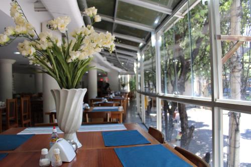 瓦拉达里斯州长市Realminas Hotel e Restaurante的用餐室,配有花瓶桌子