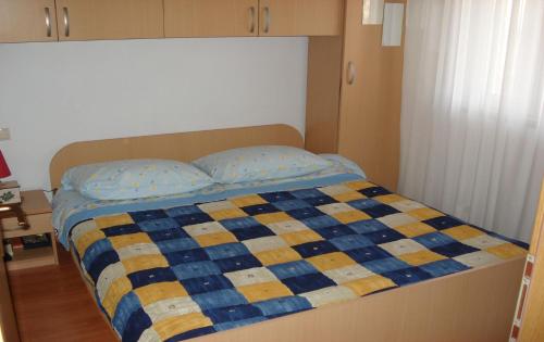 希杰弗朗吉卡Apartments Ante - 80 m from sea的床上有蓝色和黄色的被子