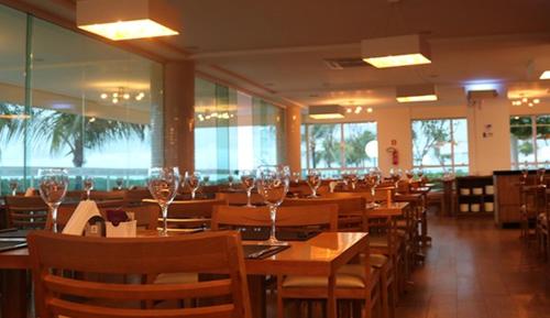 萨利诺波利斯SALINAS PARK RESORT的配有木桌和椅子的餐厅以及酒杯
