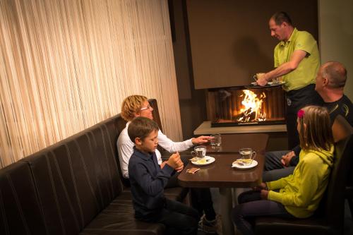 Goreljek波克尤卡中心酒店的一群人坐在餐馆的桌子旁