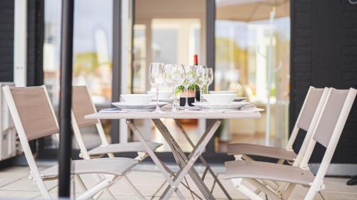 蒙斯Luxury Apart' MONS City Center with Terrace的白色桌子、椅子和酒杯