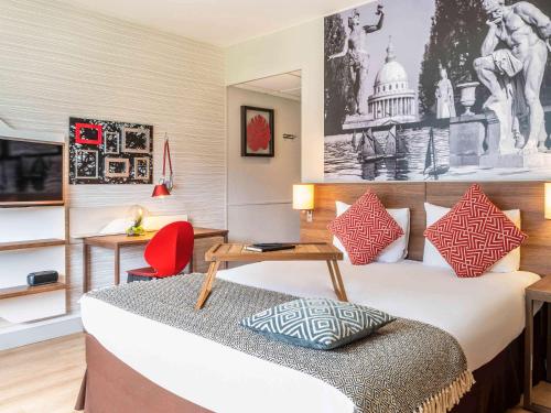 巴黎巴黎贝尔西村阿德吉奥公寓式酒店的酒店客房,配有一张床和一张红色椅子