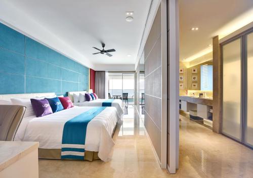峇六拜槟城丽昇豪华套房的蓝色墙壁客房的两张床