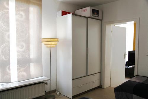 韦瑟灵Apartment am Rhein的卧室配有白色橱柜和窗户。