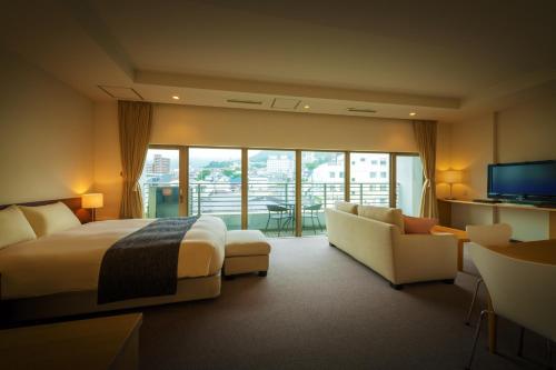 函馆康考迪亚别墅Spa度假酒店的酒店客房配有床、沙发和电视。