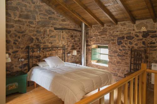 卡瓦尼亚斯Villa Valedoso的卧室配有一张石墙床