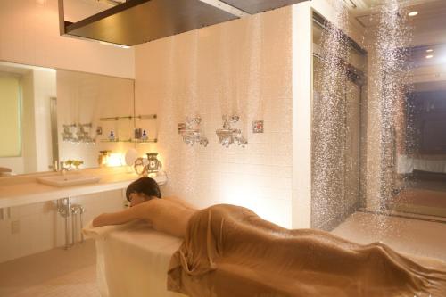 函馆康考迪亚别墅Spa度假酒店的妇女在浴室的浴缸里躺着