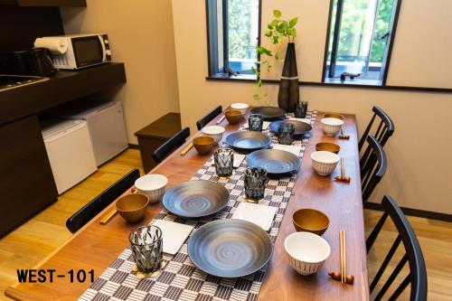 箱根Stagione Hakone Yumoto的一张木桌,上面放有盘子和碗