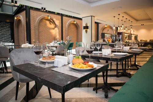 伊兹密尔Emens hotel的餐厅设有餐桌,配以食物和酒杯