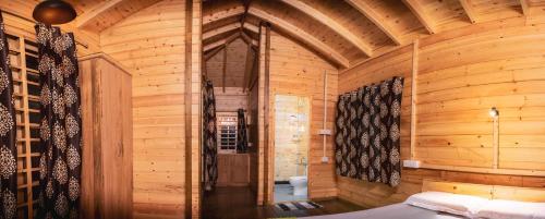 Munroe IslandGreenChromide Homestays的一间木制客房,配有一张位于客房内的床