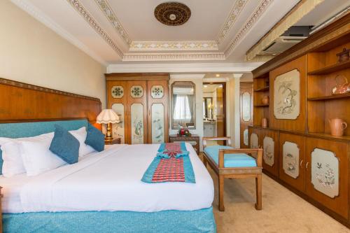 加德满都Hotel Le Himalaya by Best Resort Nepal的一间卧室配有一张大床和一把椅子