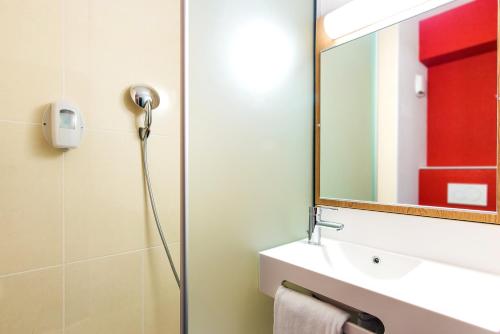 Saint-Didier-sous-AubenasB&B HOTEL Aubenas的带淋浴、盥洗盆和镜子的浴室