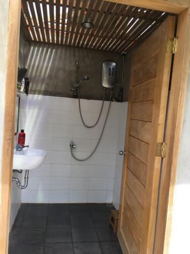 BacunganB&R Hostel Nagtabon的带淋浴和盥洗盆的浴室