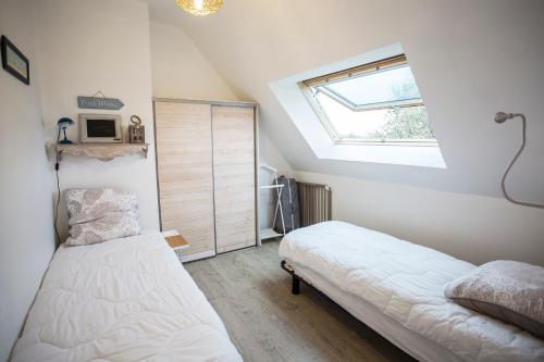 巴登La Maison Bleue的一间卧室设有两张床和窗户。
