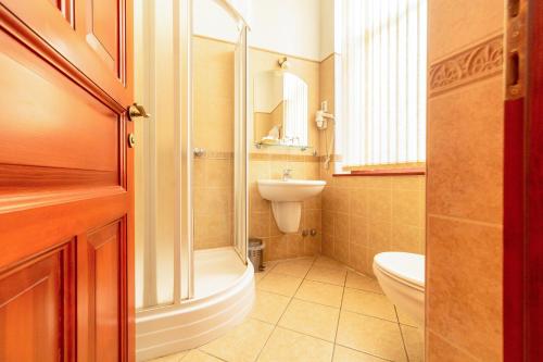 莫哈奇Pannon Hotel的带淋浴、盥洗盆和卫生间的浴室