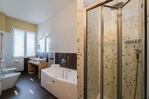 蒙特格罗托泰梅米欧尼罗依尔胜酒店的带浴缸、淋浴和盥洗盆的浴室