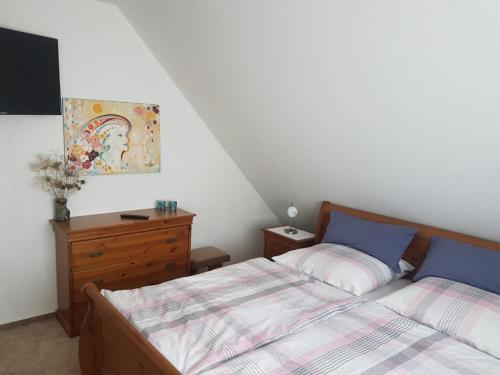 柏林Stadtnahe Unterkunft im Grünen的一间卧室配有一张床和一个木制梳妆台