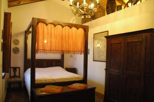 Tonco拉科尔特赫拉尔多农家乐的一间卧室配有一张天蓬床和吊灯。