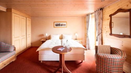尚佩里瑞士酒店的卧室配有1张床、1张桌子和1把椅子