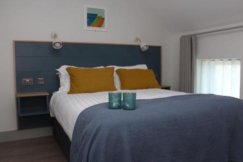 海上费萨德Baginbun Lodge的一间卧室配有一张大床,配有两把绿玻璃杯