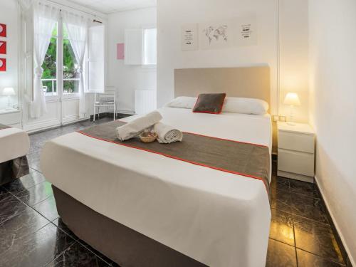 塔拉戈纳Hostal El Patio De La Luna的一间卧室配有一张大床和两条毛巾