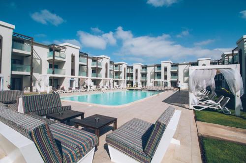 圣玛丽亚Halos Casa Resort的一座带躺椅的游泳池,位于大楼旁