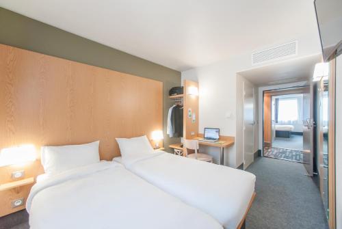 里永B&B HOTEL Clermont-Ferrand Nord Riom的卧室配有一张白色大床和一张书桌