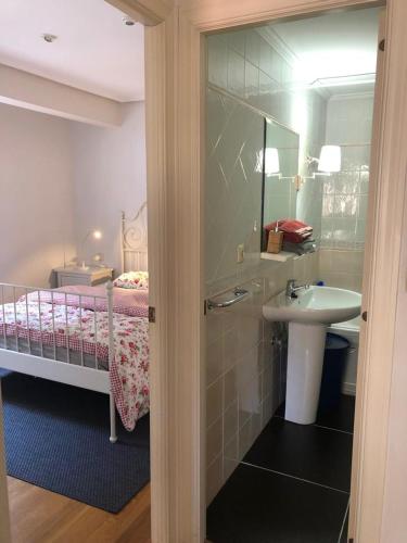 拉雷多bed and beach laredo的一间带水槽的浴室和一张带镜子的床