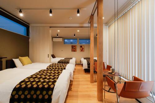 金泽MALLOWK in Kanazawa的酒店客房设有四张床和阳台。