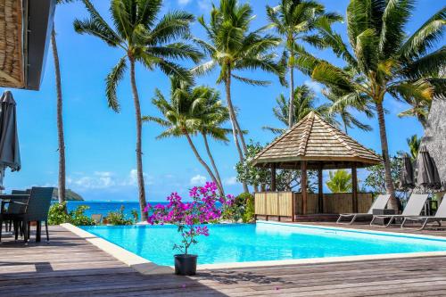 波拉波拉ROYAL BORA BORA的棕榈树度假村的游泳池和凉亭