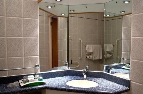 阿什福德Holiday Inn Ashford - North A20, an IHG Hotel的一间带水槽和大镜子的浴室
