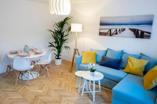 华沙CRISTINE APARTMENT的客厅配有蓝色的沙发和桌子