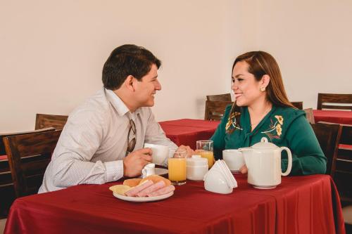 卡哈马卡Gran Hotel Guisama的坐在桌子上的男人和女人