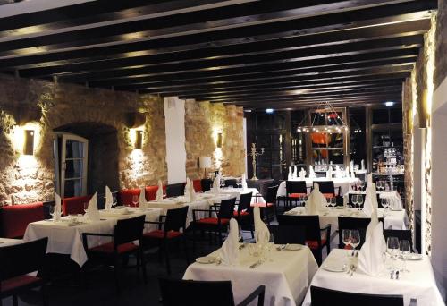 瓦尔德克瓦尔德比克酒店的用餐室配有白色的桌子和红色的椅子