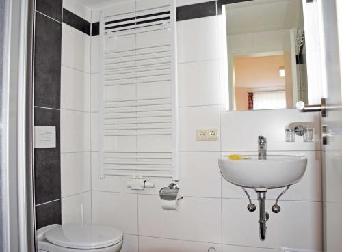 巴贝Pension Vineta Ostseebad Baabe的一间带水槽、卫生间和镜子的浴室