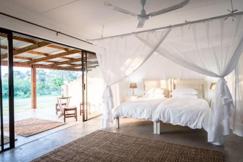 MbabatMakuwa Safari Lodge的卧室配有白色的床和吊扇
