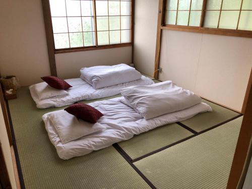 小樽Cool-Cottage Otaru OTAMOI的一间位于地板上的客房,配有两张床和枕头