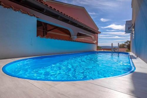 德拉马利Villa Oleander的大楼一侧的大型蓝色游泳池