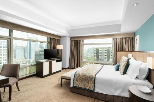 马尼拉Ascott Makati的酒店客房设有一张床和一个大窗户