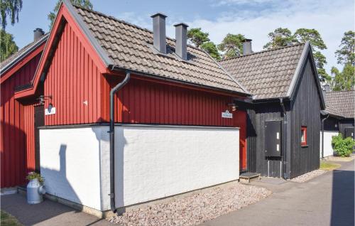 恩厄尔霍尔姆Klitterbyn 16的红色和黑色的谷仓,设有白色的车库门