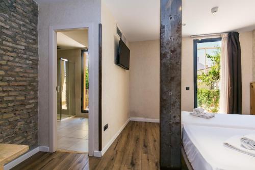 塞维利亚塞维利亚黑天鹅旅舍的浴室配有白色浴缸和石墙